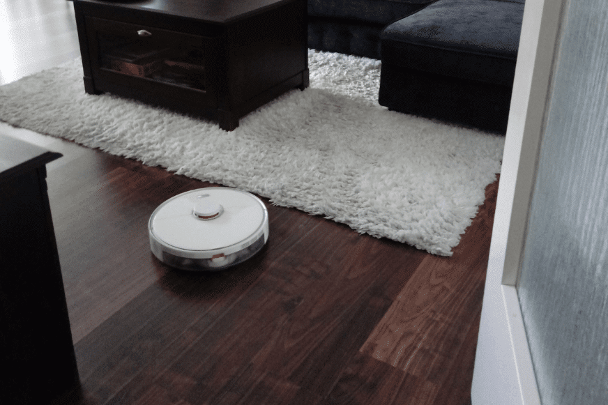 Ein Saugroboter reinigt in einer Wohnung den Boden.